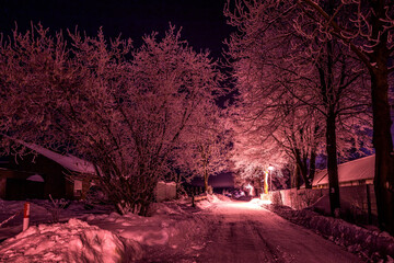 beleuchterter Weg im Schnee bei Nacht 