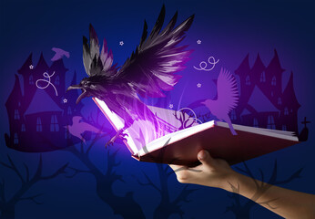 Hand holding book with drawn magic world on dark color background