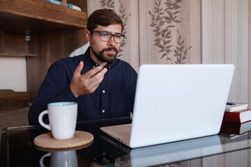 Focused man sitting at desk watching webinar video course