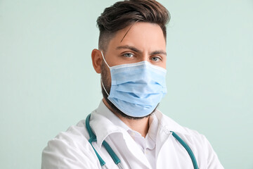 Male doctor on color background