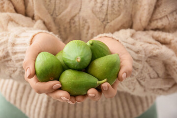 Woman holding fresh green figs, closeup