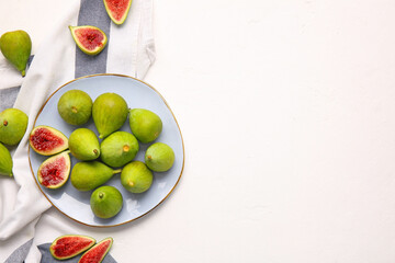 Plate with fresh green figs on white background