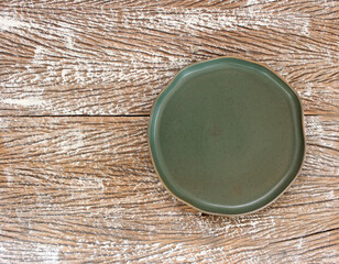 Empty modern ceramic plate on wood table background ,top view