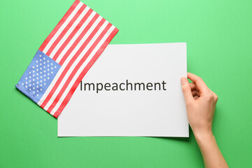 USA flag and hand holding paper with text IMPEACHMENT on color background