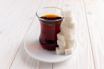 A glass of tea and a pile of sugar cubes. Eating too much sugar concept.