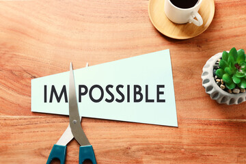 card with the text impossible, cutting the word im so it written possible. success and challenge...