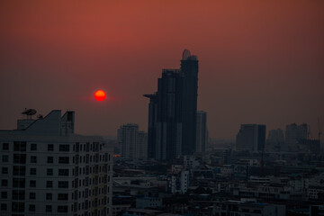 Fototapeta premium The high angle background of the city view with the secret light of the evening, blurring of night lights, showing the distribution of condominiums, dense homes in the capital community