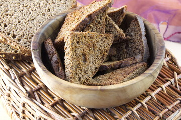 Homemade rye croutons made from black rye bread in a wooden bowl on the table