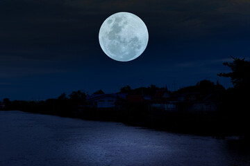 Full moon on sky over river at night.