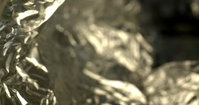 Silver crumpled foil. Shiny metal texture. Wrapping paper for wallpaper decoration background. Zoom out. High quality. 4k footage.