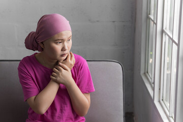 Portrait of sad Asian woman cancer patient after suffering serious hair loss due to chemotherapy