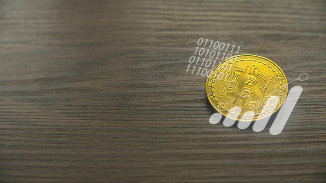 Bitcoin cryptocurrency concept with a graph and binary code on wooden background with copy space.