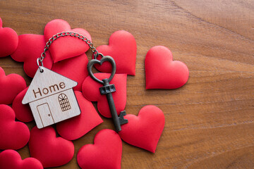 House key with home keyring decorated with mini heart on rusty wood background - 414858793