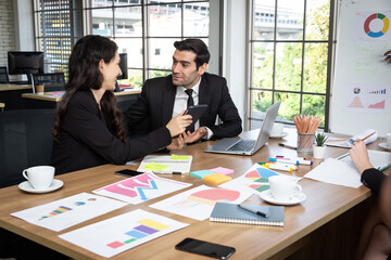 Male office workers chatting happily with young colleagues in the conference room. The manager tries to create a good atmosphere during meetings with the sales team.