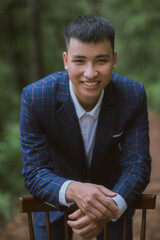 Asian groom portrait in forest
