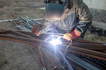 A worker welds metal for a canopy.