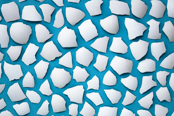 pattern of white pieces of eggshell on blue, Easter background. Happy easter concept