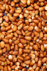 Background of peeled pine nuts from Siberia, milky color with a yellow dry skin. 