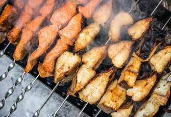 Fish kebab on skewers on the grill in winter. Salmon and halibut