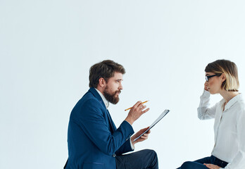 Woman and man are sitting on the couch in suits psychology papers