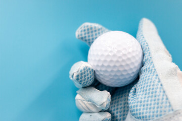 Golfer is holding golf ball on blue background