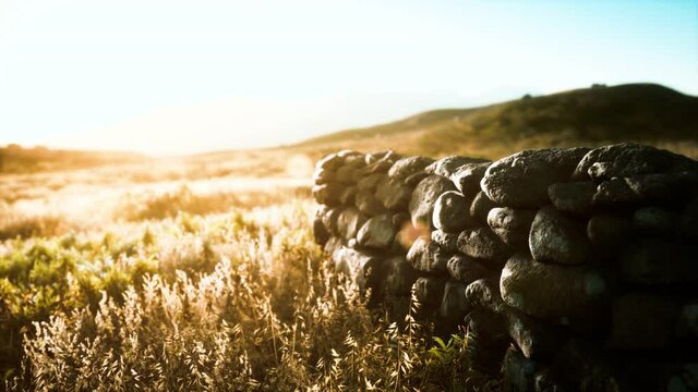 Scottish land border stone wall at sunset