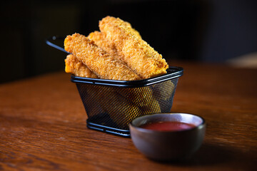 cheese sticks with sauce on a wooden table