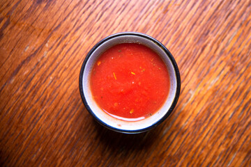 hot red sauce in a sauce bowl on a wooden table