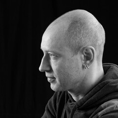 bw portrait of a bald man on a black background