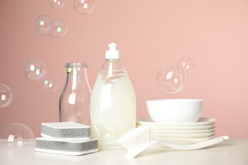Cleaning tools, plates and soap bubbles on pink background. Dish washing supplies