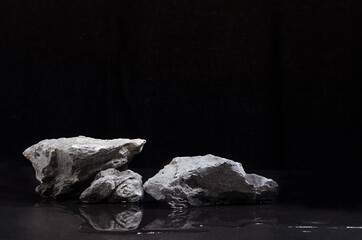 Luxury natural stone podium with water as shore at night for showing packaging and product on black background.