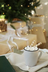 Cup of cocoa with wafer tubes on table indoors. Christmas celebration