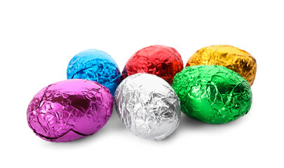 Many chocolate eggs wrapped in bright foil on white background