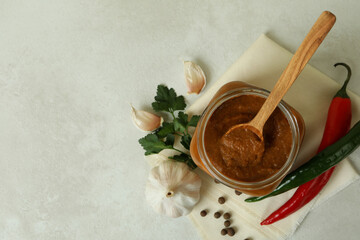 Jar with zucchini caviar on white textured table
