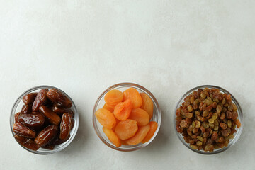 Glass bowls with dried food on white textured background