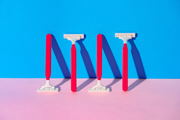 Disposable razor on blue and pink background