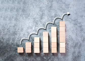 Wooden block stacking as ladder, step stairs with white arrow up on gray background, Concept of success in business growth, copy space