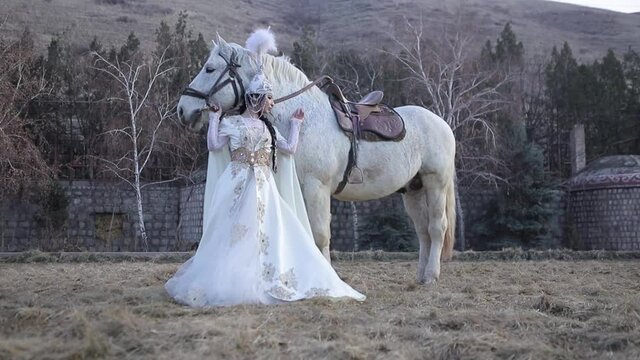An Asian girl in a national costume is riding a horse. Kyrgyz national costume.