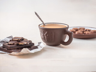 Delicious lunch with coffee and chocolate. Broken chocolate bar with filling and candies