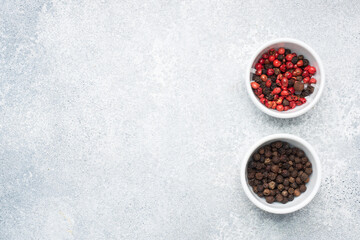 Pepper peas black and red in plates, gray concrete background, copy space.