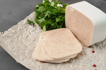 Meat sausage on parchment on gray background