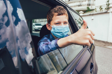 Kids wearing anti virus masks in the car. Kids are travelling in car during coronavirus outbreak