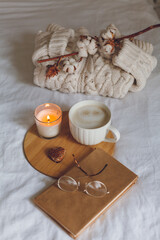 Breakfast in bed. Coffee mug, heart-shaped cookies, book, glasses, candle, wooden tray. Women's Day. Cozy.