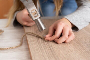 Young woman working in craft workshop with various tools and materials.