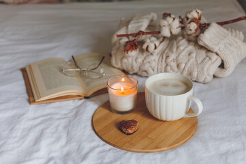 Breakfast in bed. Coffee mug, heart-shaped cookies, book, glasses, candle, wooden tray. Women's Day. Cozy.