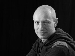 bw portrait of a bald man on a black background