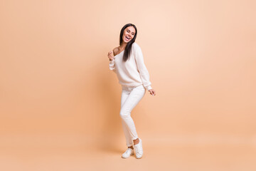Fototapeta na wymiar Full body photo of young excited girl happy positive smile have fun enjoy music dance isolated over beige color background