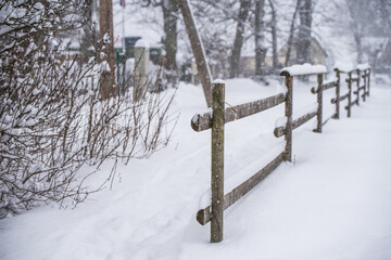 Fototapeta premium Wooden fence in the snow on winter country background