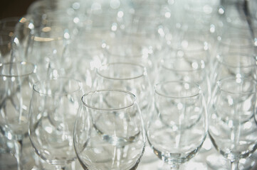 A lot of wine glasses receding into the distance into the blurred background.