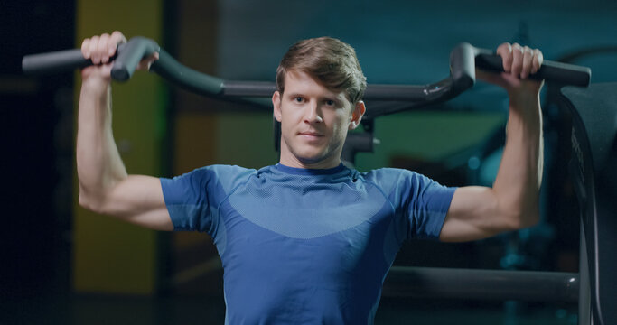 Determined Young Male Sportsman Fitness Workout On Pull Down Machine Fitness Center Healthy Life Persistence Health Focused Fitness Concept - Powered by Adobe